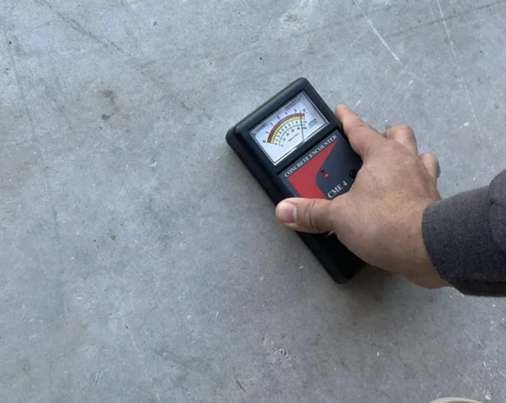 Contractor performing concrete moisture test with CME-4 Concrete Encounter meter on garage slab before quoting final coating price