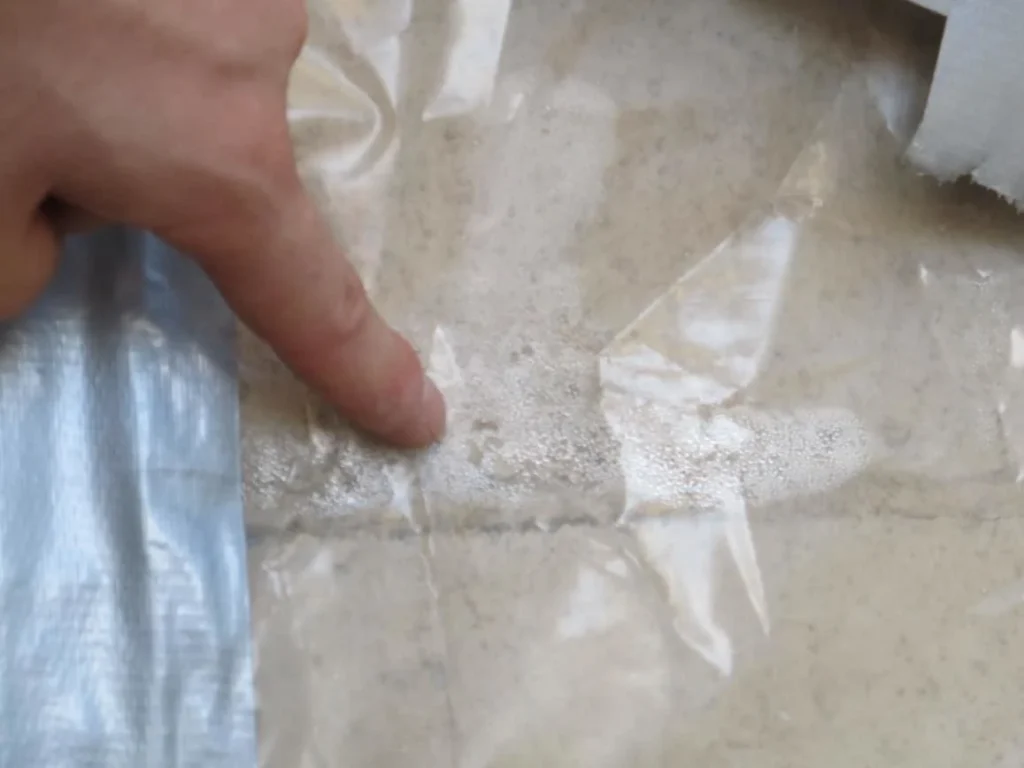 Concrete moisture vapor transmission test showing condensation under plastic sheet taped to Kansas City garage slab